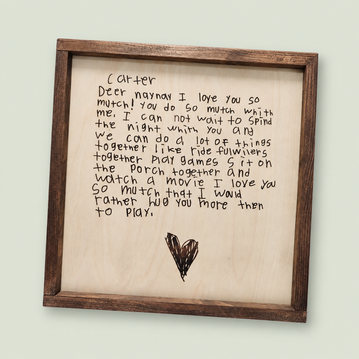 Framed wooden keepsake engraved with a child's handwritten note and heart drawing.