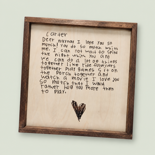 Framed wooden keepsake engraved with a child's handwritten note and heart drawing.