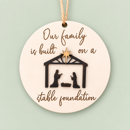 Round layered nativity ornament reading Our family is built on a stable foundation.