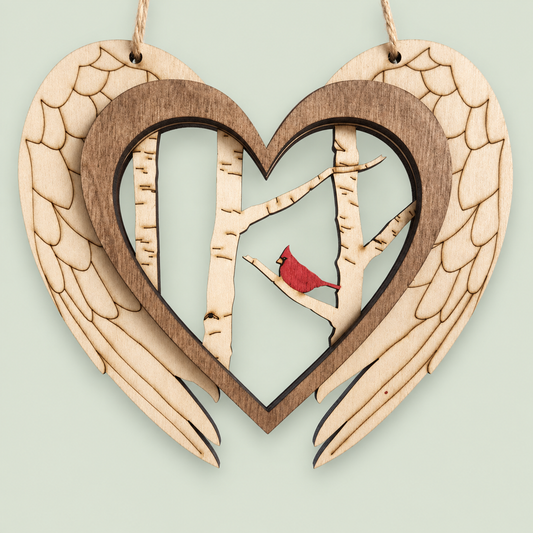 Wooden memorial ornament with angel wings, a heart frame, birch trees and one red cardinal.