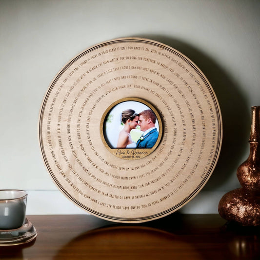 Round wooden wedding keepsake with a couple's photograph and engraved song lyrics.